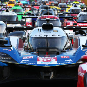 Dozen and dozens of racing cars lined up on the start line at Le Mans