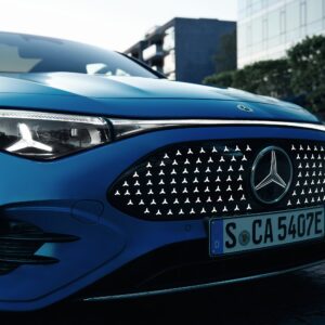 A closeup of the front of a blue Mercedes-Benz CLA with EQ technology.
